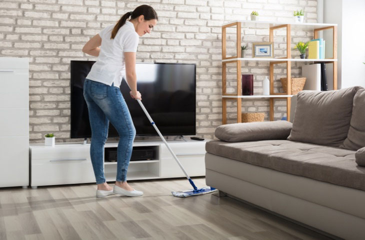 Woman cleaning hardwood floor | ICC Floors Plus