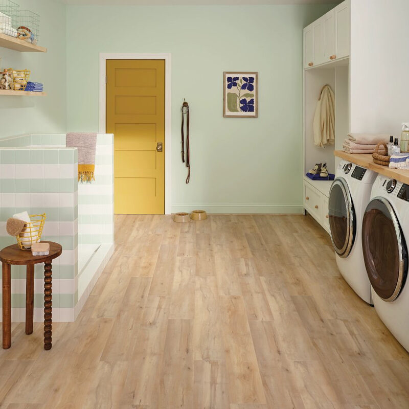 Laundry room with light wood flooring and yellow door