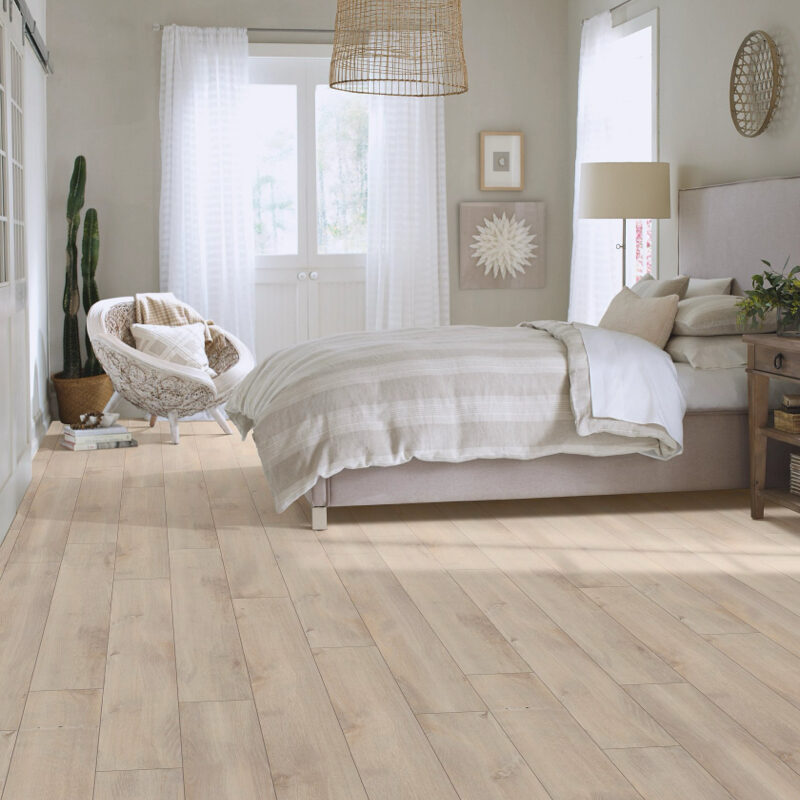 Bedroom with wide-plank wood flooring and neutral decor